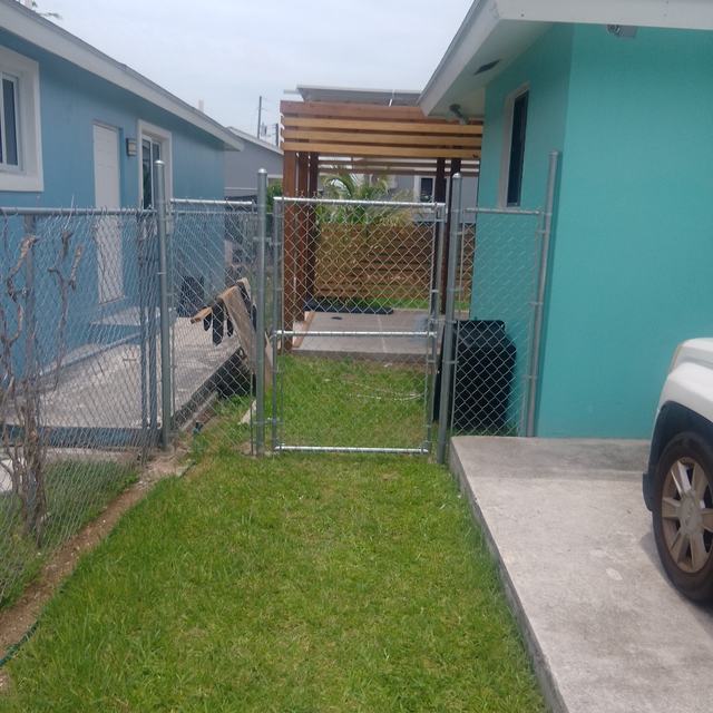 Fence and gate beside a teal house